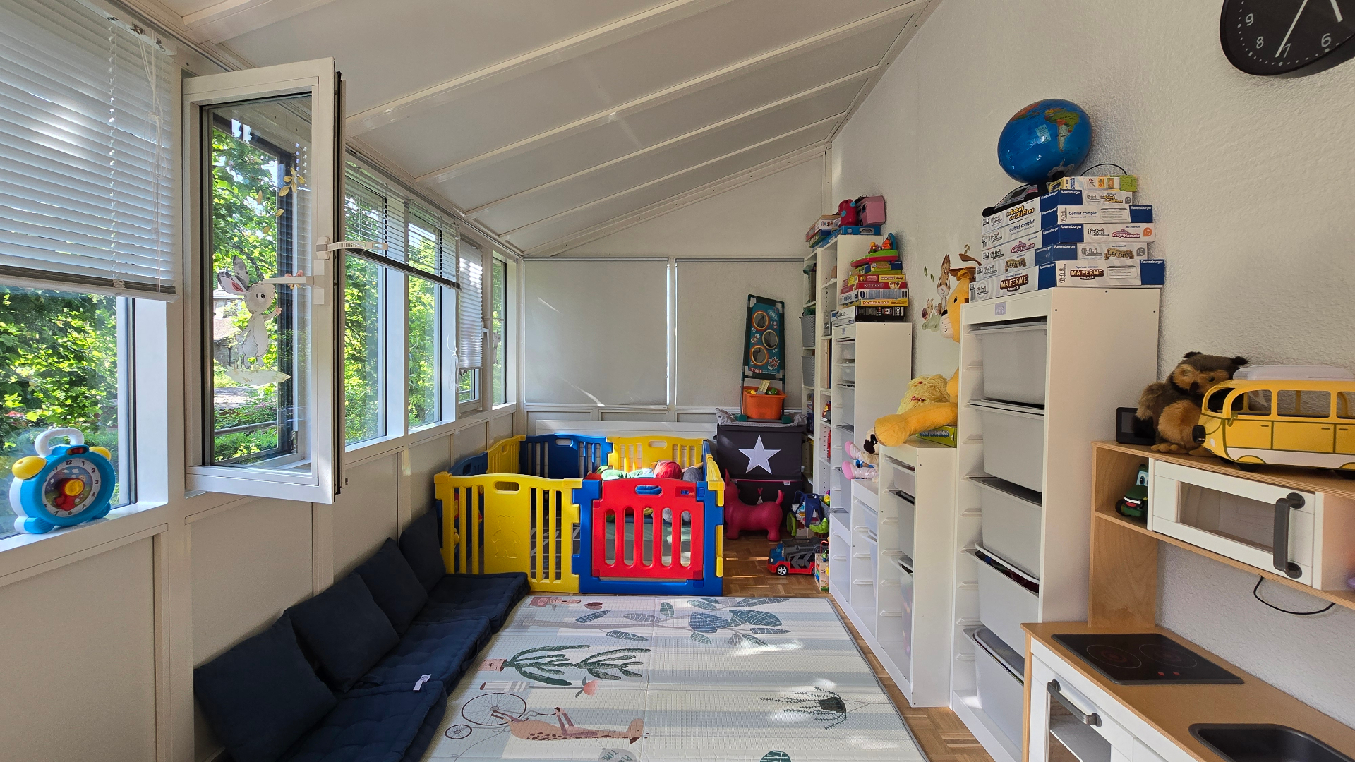 Salle de jeux baignée de lumière naturelle avec vue sur le jardin